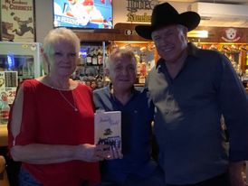 Readers holding The Family Gold at a pub