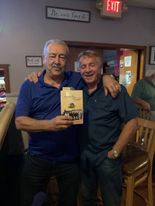 Two readers with The Family Gold at a restaurant