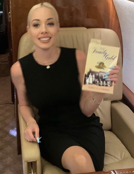 Reader holding The Family Gold aboard a private jet