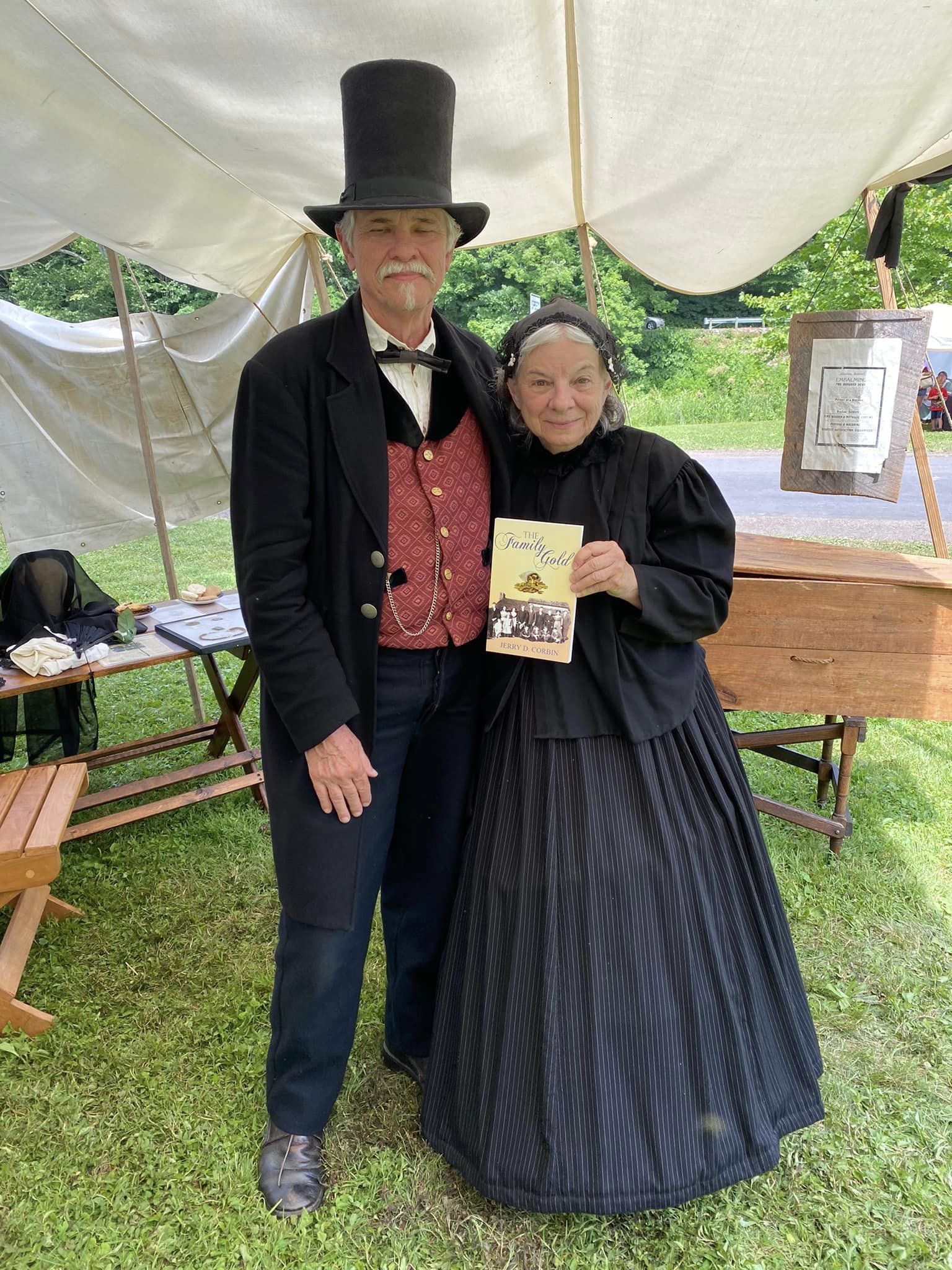 Period-dressed couple holding The Family Gold