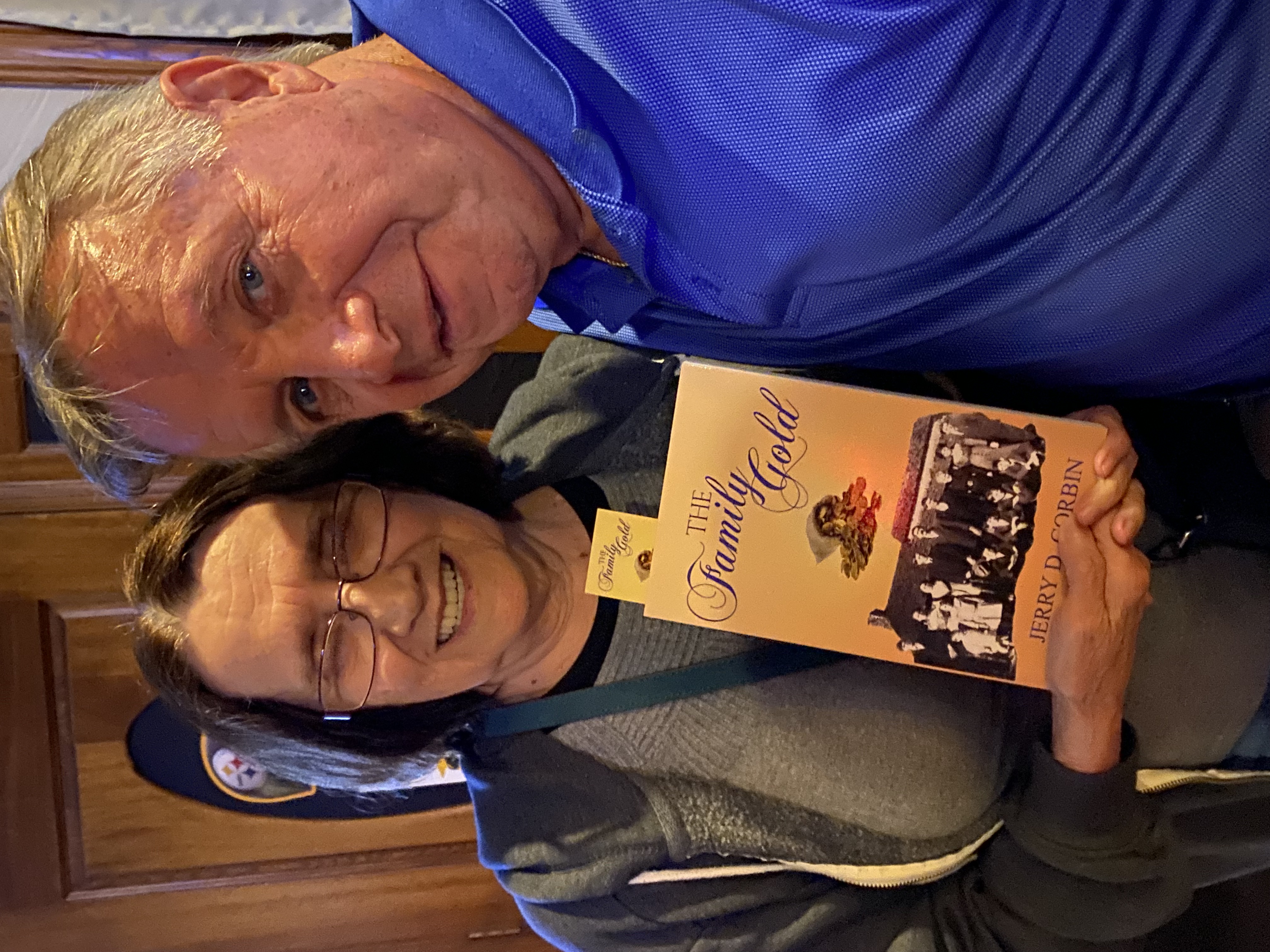 A couple holding The Family Gold and a bookmark