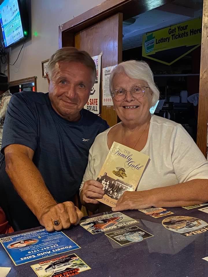 Reader holding The Family Gold at a local pub